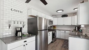 A modern kitchen with white cabinets, stainless steel appliances, and a coffee station. - Pet-Friendly | Large Group | Hot Tub - All Year (Bay City)