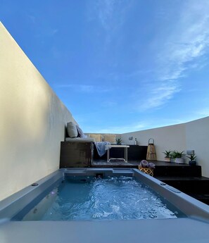 A hot tub with a view of the sky, a seating area with cushions, and a small table with a plant. - Room-luxury Suite With a Queens Double b (Skiathos)
