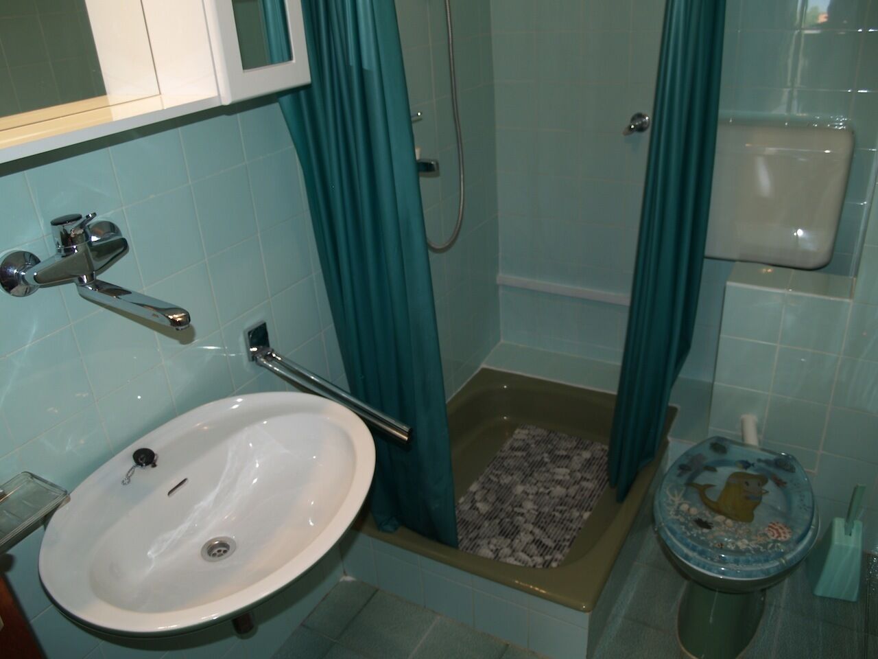 Un baño con lavamanos, ducha e inodoro.