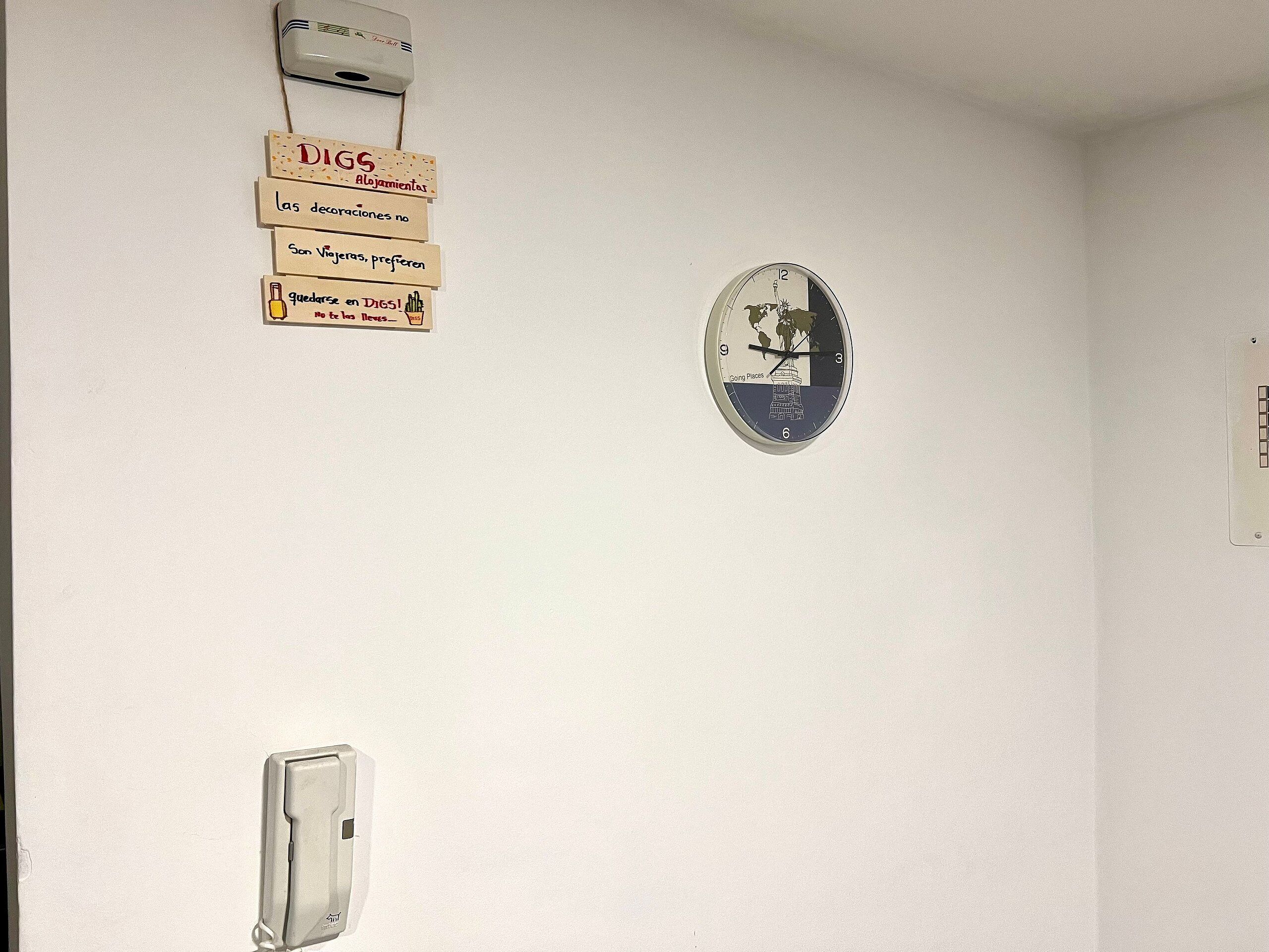 Un muro con un orologio, un termostato e diverse indicazioni.