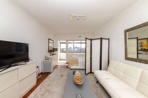 Departamento básico, 1 cama matrimonial | Área de sala de estar | Televisión 