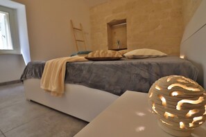 A bedroom with a bed, pillows, a bedside table, and a decorative lamp. - Dimora Storica Rebecca Salento Charm and Modern Comfort in the Heart of Otrant (Otranto)