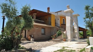 A two-story house with a balcony, a stone staircase, and a garden area. - Holiday Home Chevalier With Terrace and Swimming Pool (Itri)