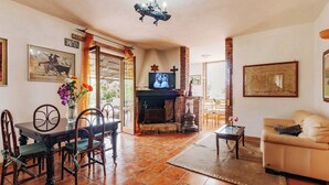 A cozy living room with a fireplace, a dining area with a table and chairs, and a sofa. - Holiday Home Chevalier With Terrace and Swimming Pool (Itri)