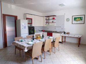 Enjoy meals in this cozy kitchen with a dining table for four, complete with a refrigerator, stove, and sink.
