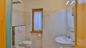 A small, clean bathroom with a toilet, bidet, and sink. - Apartment La Gran Becca - ID 527 (Antey-Saint-Andre)
