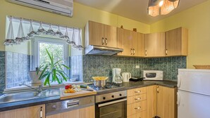 Une cuisine avec des meubles de rangement en bois, une cuisinière, un four à micro-ondes et un réfrigérateur.