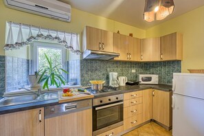 A kitchen with wooden cabinets, a stove, a microwave, and a refrigerator.