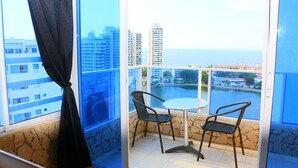 A balcony with two chairs and a table, overlooking a body of water and buildings. - Apartment in Cartagena Ocean Front Num1c5 (Cartagena)
