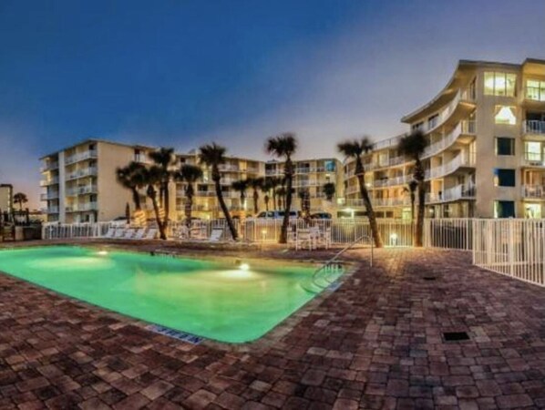 Ein Hotel mit Pool, mehreren Balkonen und Palmen.