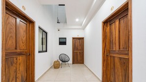 A hallway with wooden doors, a chair, and a small table.