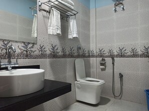 A bathroom with a sink, toilet, and towel rack. - Atithya Resort (Sonapur)