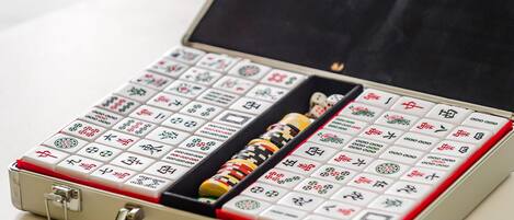 A mahjong set in a metal case with a red interior lining.