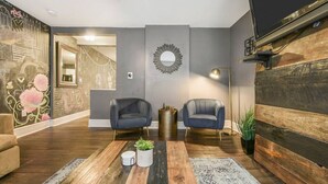 A modern living room with two armchairs, a coffee table, and a patterned rug. - M&J - 823 James St. (Pittsburgh)