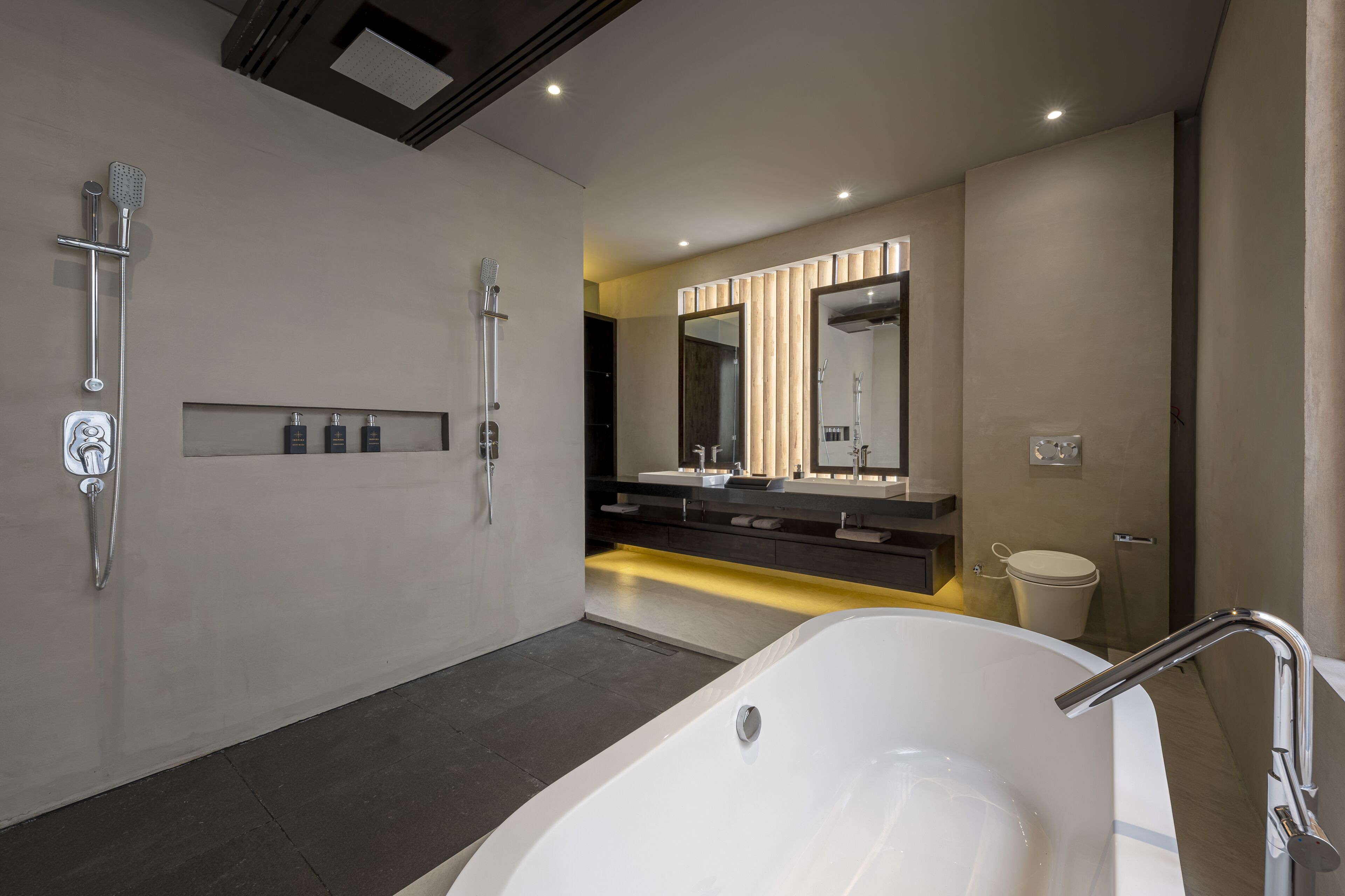 Een moderne badkamer met een groot bad, een ruime douche en een wastafel met spiegel.
