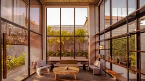 A modern interior with large windows, a wooden coffee table, and a sofa.