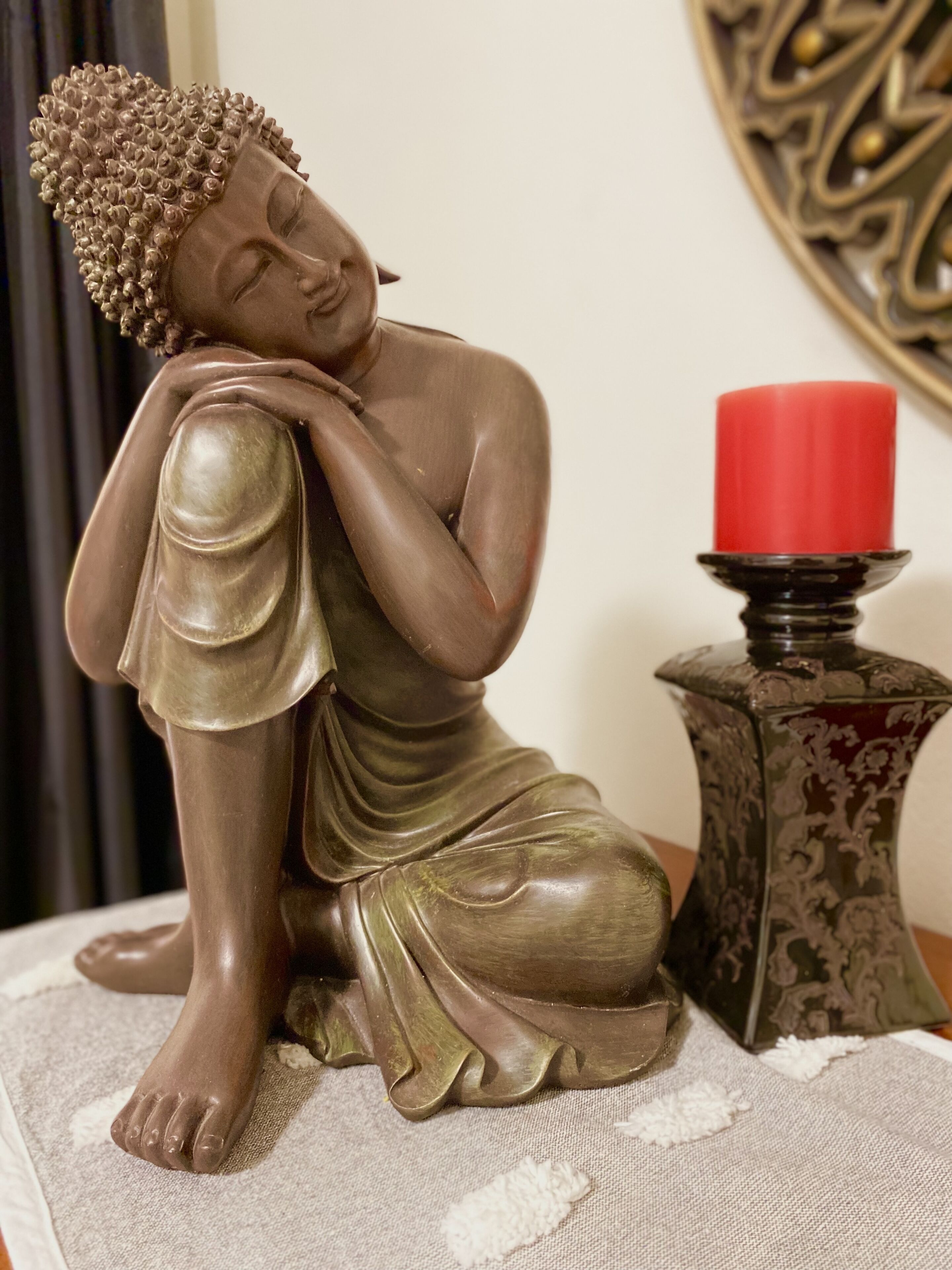 Una estatua de Buda con una vela roja a su lado.