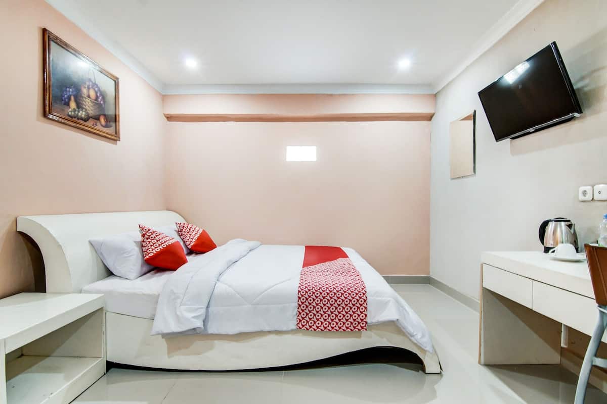 Une chambre à coucher moderne, avec un lit, des tables de chevet, un bureau, une télévision et un tableau au mur.