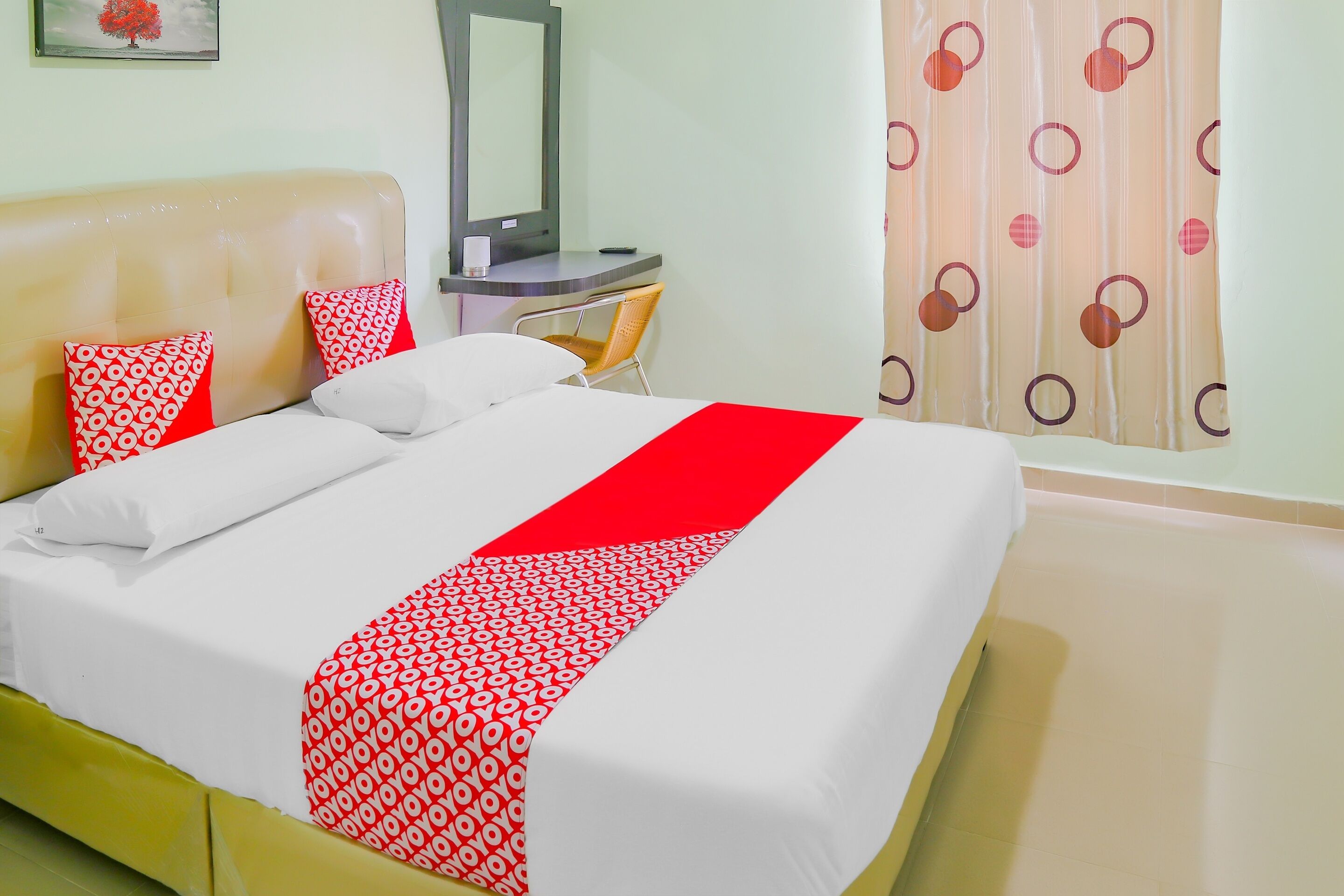 Une chambre d’hôtel avec un lit, un bureau, une chaise et un miroir.