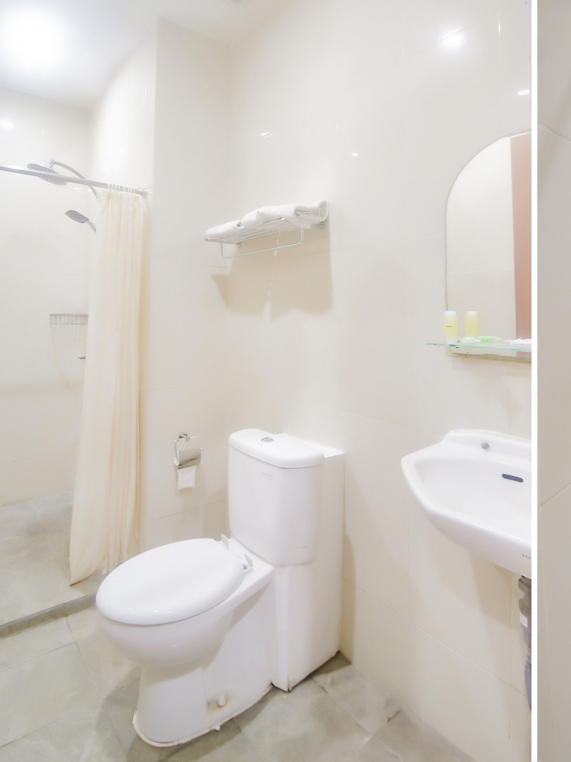 A bathroom with a toilet, a shower, and a sink.