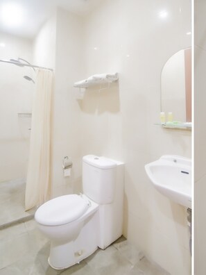 A bathroom with a toilet, a shower, and a sink. - OYO 90312 Bahu Bay Hotel (Manado)