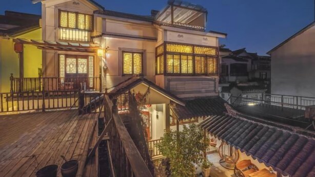 A traditional building with multiple levels, wooden railings, and a balcony. - Yuyantang Riverside Courtyard Boutique Inn (Kunshan)
