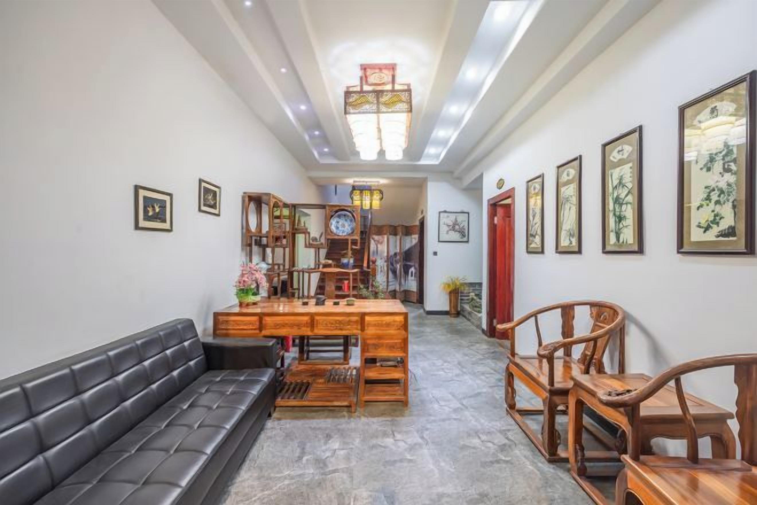 Un pasillo con sofá, muebles de madera y cuadros en las paredes.