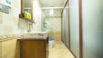 Une petite salle de bain avec un meuble-lavabo en bois, un lavabo blanc et des toilettes.