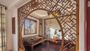 A traditional room with a wooden bench, a decorative screen, and a view through a window. - Yuyantang Riverside Courtyard Boutique Inn (Kunshan)