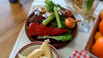 Een tafel met een salade, brood en een glas water.