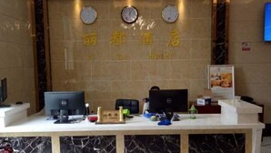 A hotel reception desk with two monitors, a clock, and a sign above the desk. - Lijing Hotel (Zhong County)