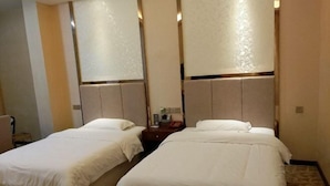A hotel room with two beds, a nightstand, and a wall-mounted lamp. - Lijing Hotel (Zhong County)