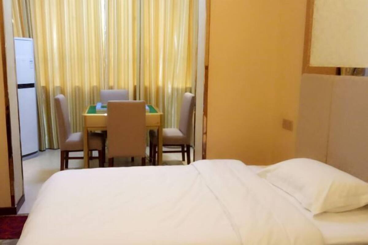 A hotel room with a bed, a small table, and chairs.