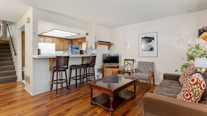 A compact living space with a kitchen area, a dining table, a sofa, and a television. - Heavenly Chairview Condo 2 Bedroom Home by RedAwning (Stateline)