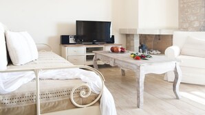 A bedroom with a bed, bedside table, TV, and a fireplace. - Two Bedroom Villa With Attic - Dalia (West Mani)