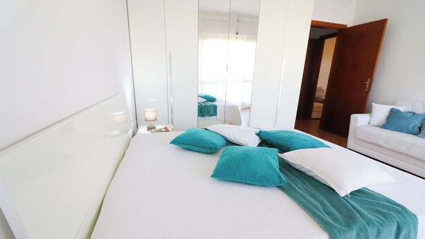Ein Hotelzimmer mit einem Bett, einem weißen Sofa und einem Spiegel.