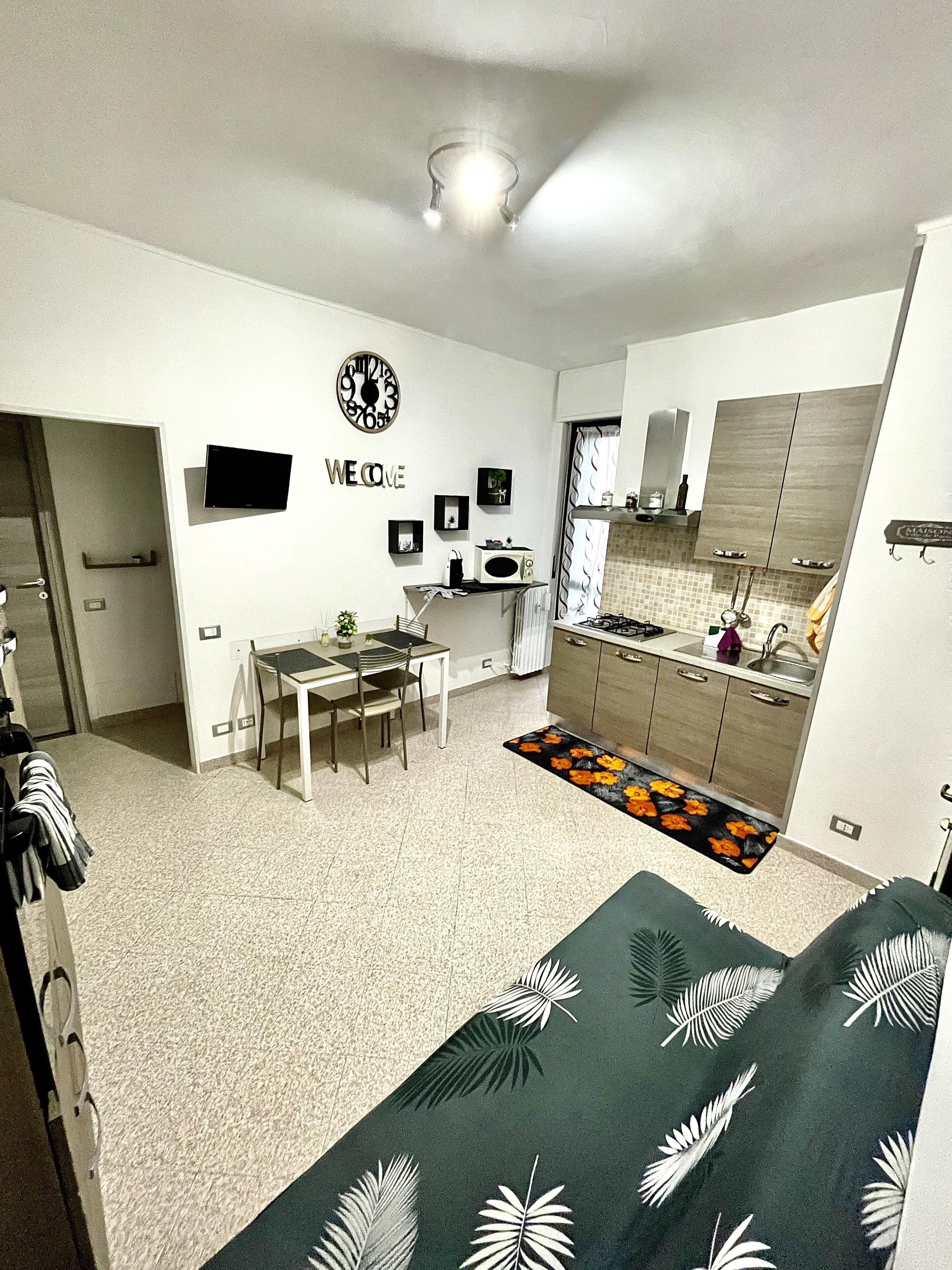 Una cocina moderna con comedor, televisor de pantalla plana y un cartel que dice 'WELCOME'.
