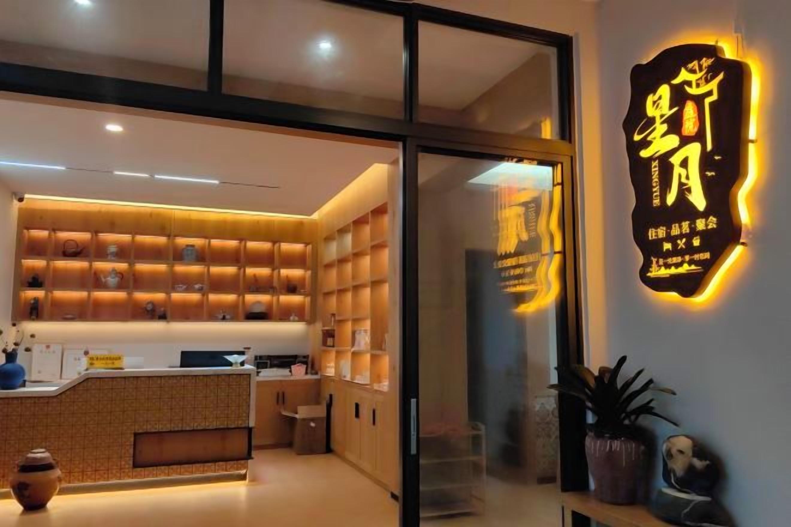 A modern interior with a reception desk, shelves with items, and a neon sign.