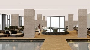 A spacious lobby with high ceilings, large windows, and a central circular water feature. - Sirius Hotel (Keszthely)