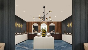 A modern hotel lobby with a central reception desk, a chandelier, and a blue patterned carpet. - Sirius Hotel (Keszthely)