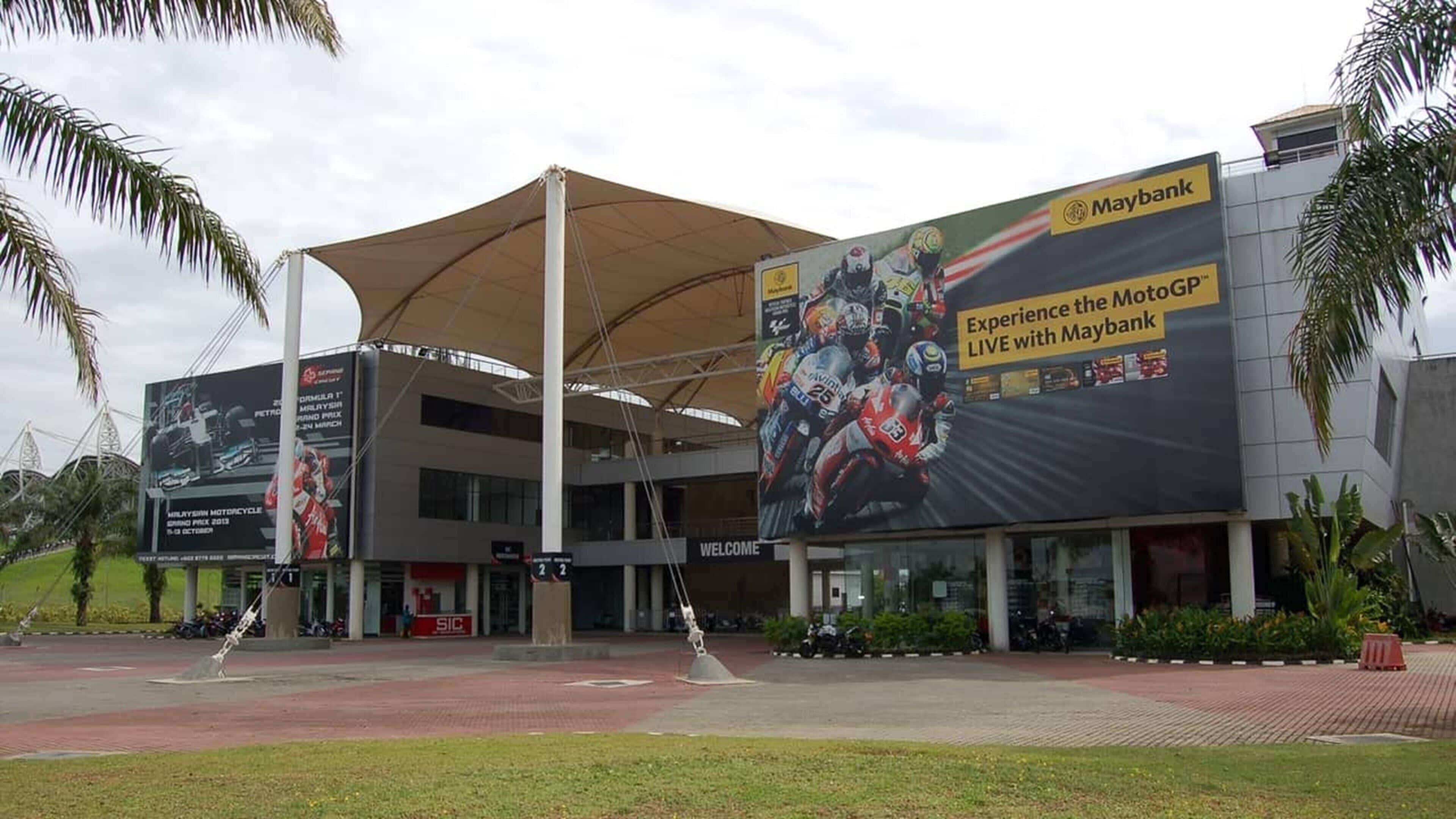 A modern building with a large outdoor advertisement for Maybank.