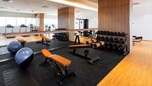 A modern gym with exercise equipment, benches, and a mirrored wall. - Holiday Inn Sepang Airport by IHG (Sepang)