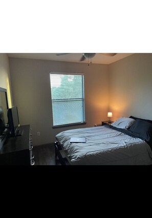Cozy retreat with a single bed, bedside table, and dresser, offering a peaceful space to rest.