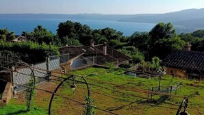 A residential area with houses, a swimming pool, and a view of the sea. - La Rosa - Romantic lake view apartment (Trevignano Romano)