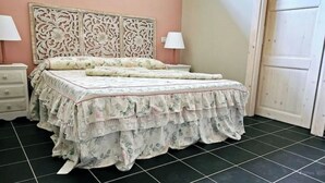 A bedroom with a bed, two bedside tables, and a door. - La Rosa - Romantic lake view apartment (Trevignano Romano)