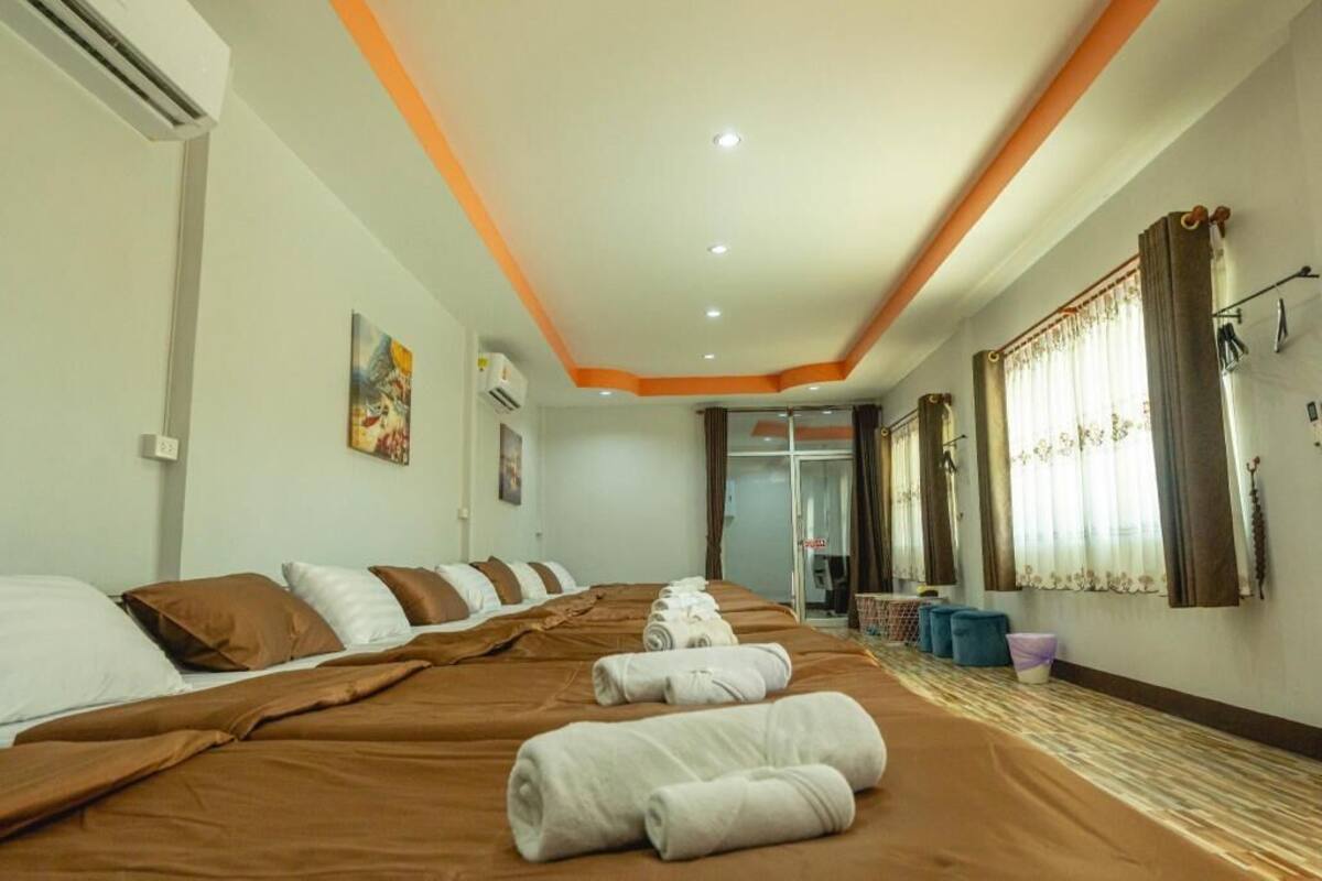 Habitación de hotel con una cama grande, baño con puerta de cristal y ventana con cortinas.