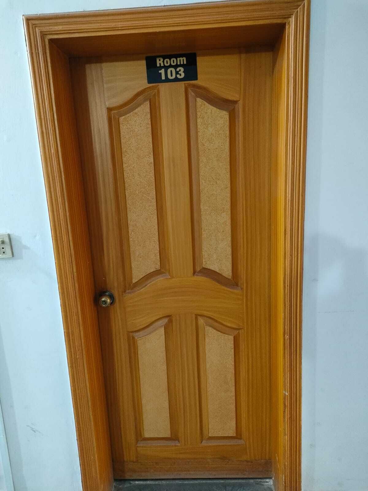 A wooden door with a sign reading "Room 103".