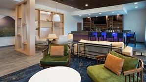 A modern lounge area with a bar, seating, and a large screen. - Fairfield Inn & Suites By Marriott Austin Georgetown (Georgetown)