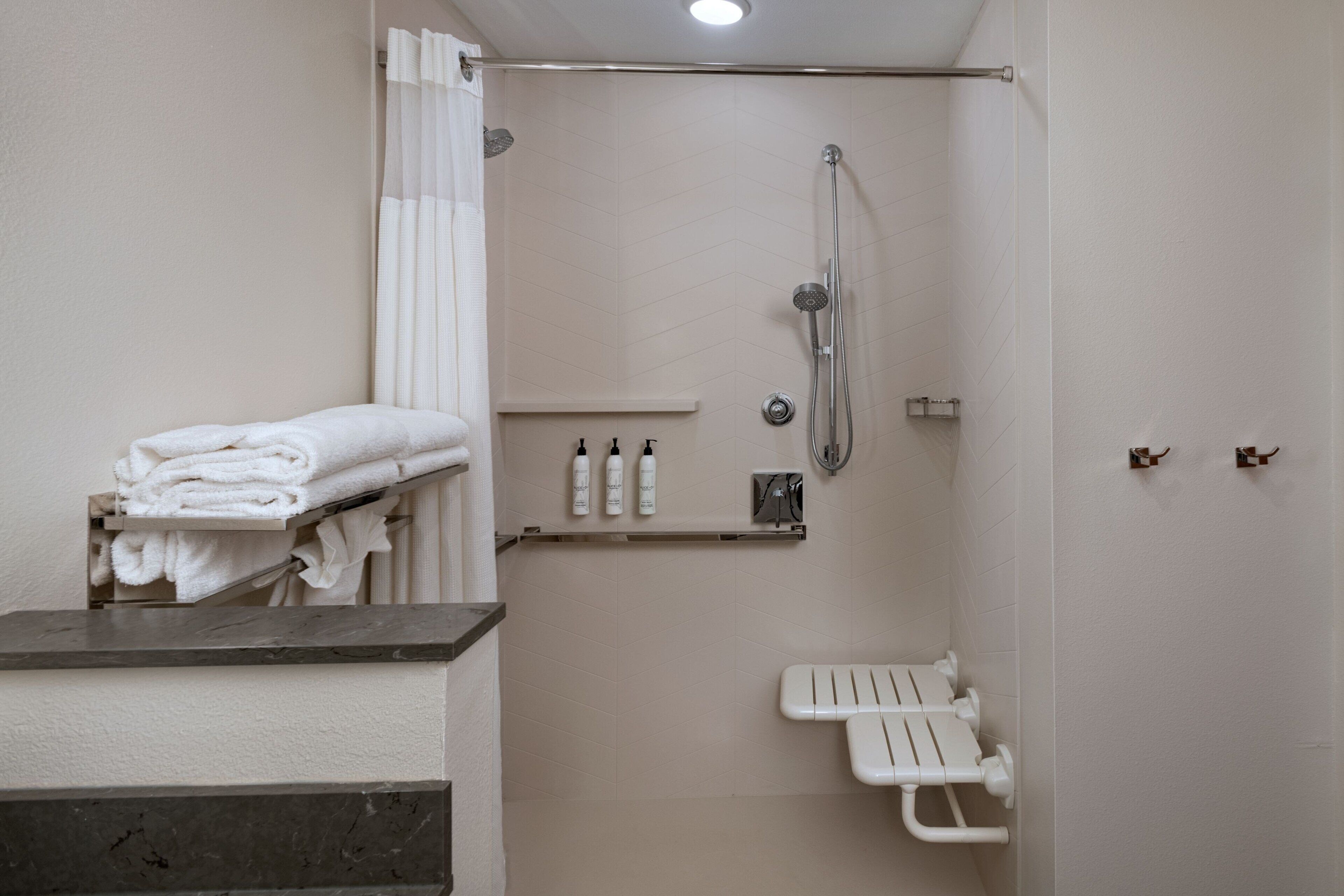 A bathroom with a shower, a toilet, and a towel rack.