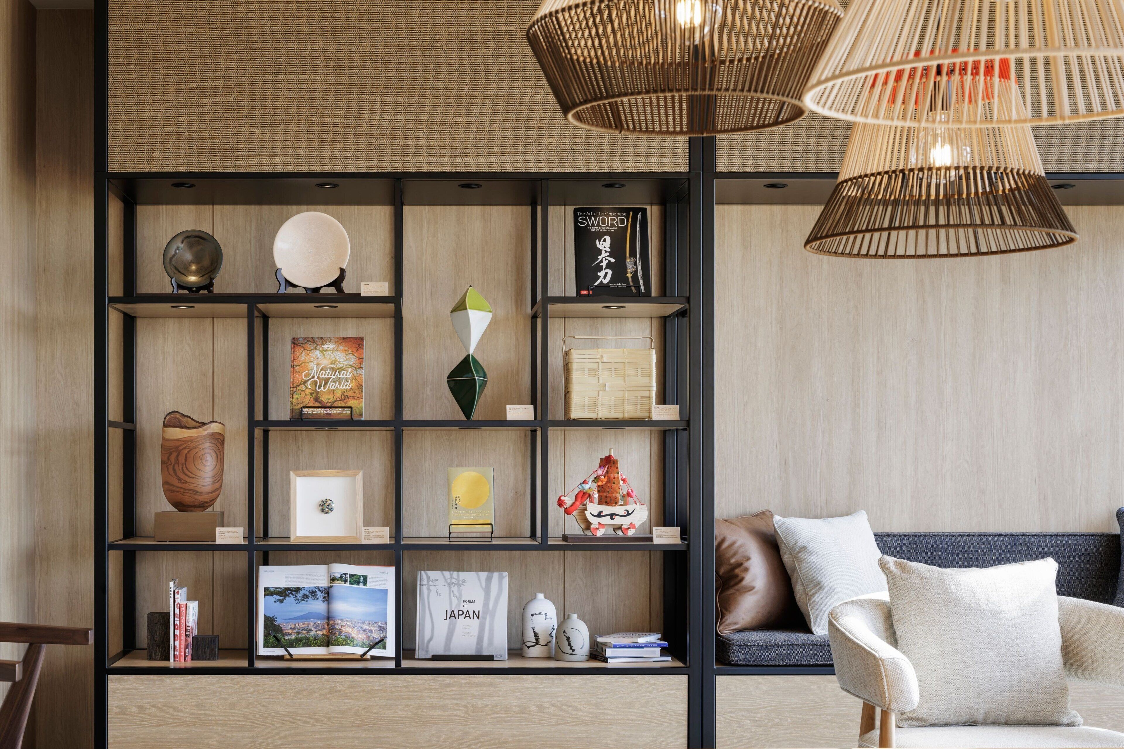 Una sala de estar moderna con una estantería de madera, un sofá y una lámpara colgante.